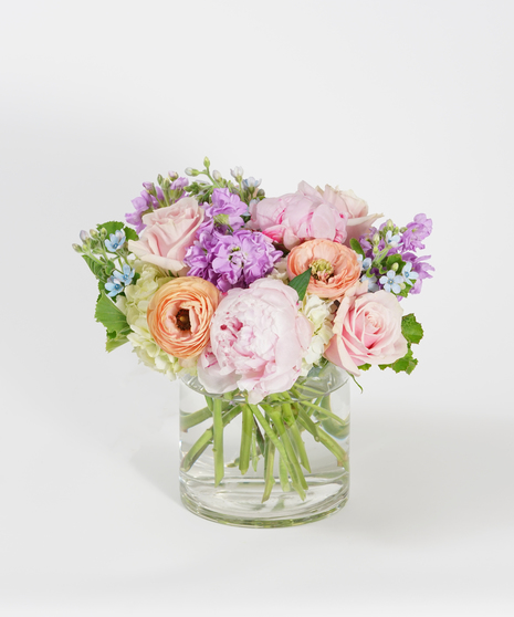 floral arrangement of soft pink peonies, peach ranunculus and white hydrangea.