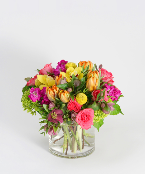 low floral design of orange tulips, hot pink roses, and yellow orchids