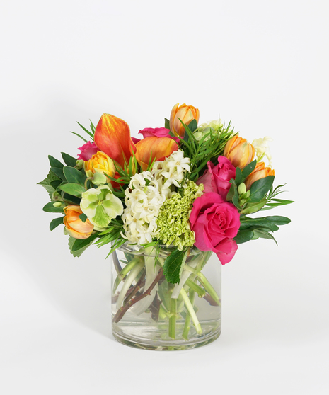 low and lush floral design of mango calla lilies, hot pink roses, and tangerine tulips