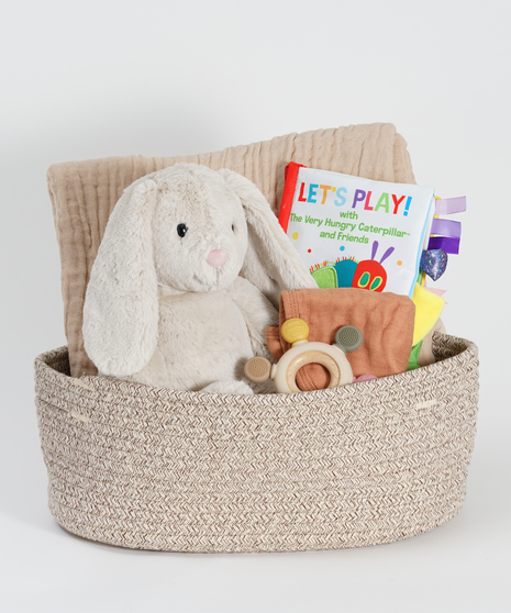 new baby gift basket featuring plush bunny, blanket, and baby books.