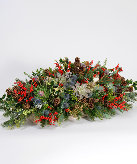 Christmas centerpiece of evergreens, berries, succulents and pinecones
