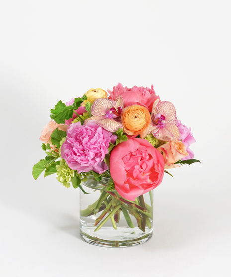 floral design of coral and hot pink peonies accented with peach roses, orchids, and ranunculus
