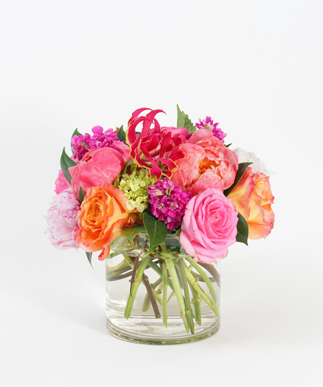 lush floral design of pink peonies, orange roses and peach ranunculus
