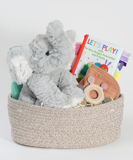 new baby gift basket featuring plush elephant, blanket, and baby books.