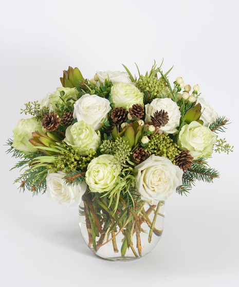 winter floral design of white and green roses accented with wintergreens and white berries