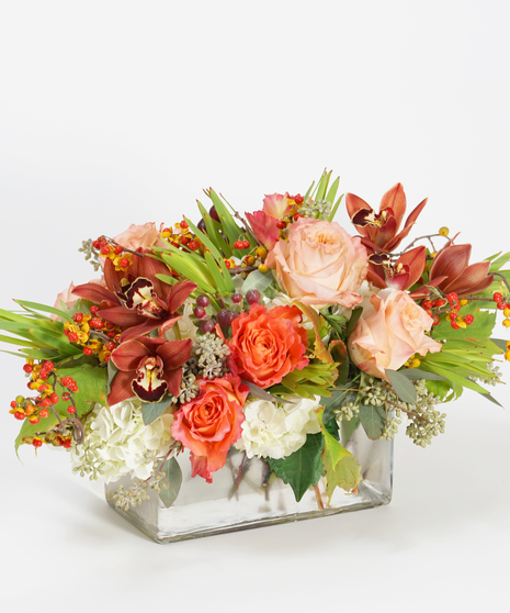 Thanksgiving centerpiece of orange and peach roses, bronze orchids and bittersweet