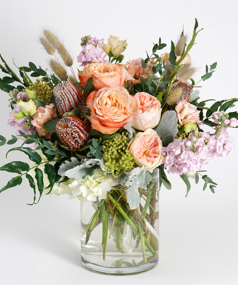 peach roses and white hydrangea accented with banksia, holly fern and silver brunia