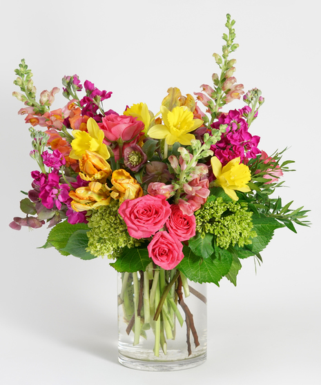 gardeny floral design featuring yellow tulips, orange snapdragon, and hot pink spray roses