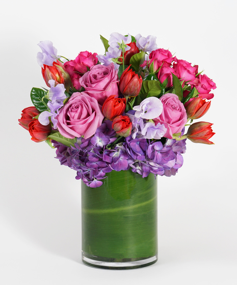 Valentine's Day arrangement of purple hydrangea, lavender sweet pea, red tulips, and hot pink spray roses