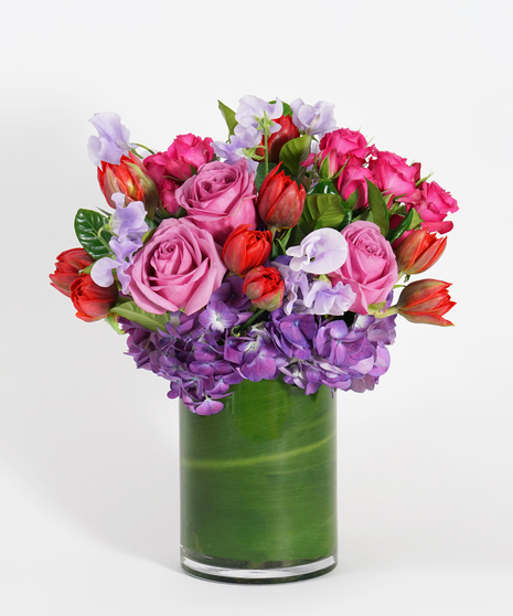 Valentine's Day arrangement of purple hydrangea, lavender sweet pea, red tulips, and hot pink spray roses