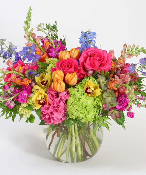 luxury floral design of hydrangea, roses, and orchids in shades of hot pink, magenta, orange, and green.