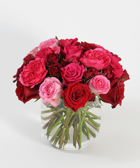 pink and red roses and garden roses in cylinder vase
