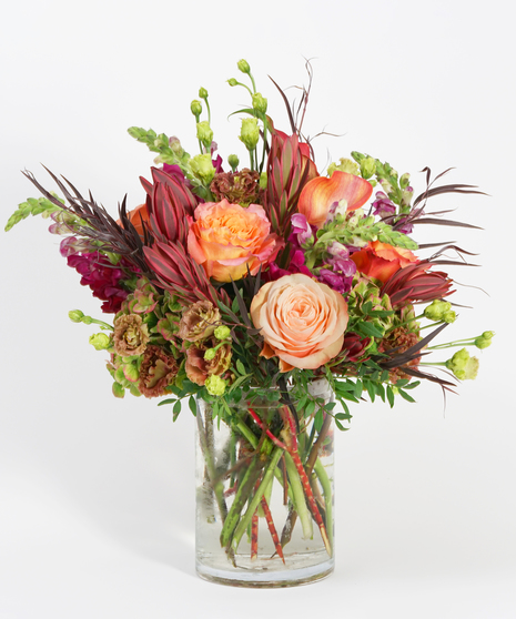 textural fall floral design with peach roses, mango calla lilies, and terracotta lisianthus