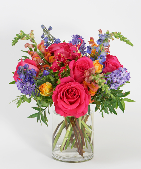 colorful floral design of tangerine tulips, blue hyacinth and hot pink roses