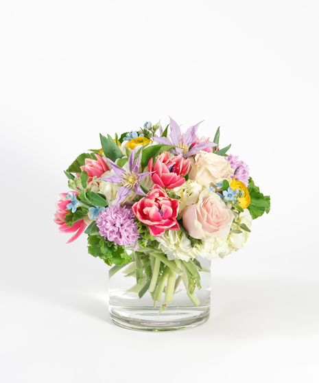 Spring floral design of pastel tulips, hyacinth, roses and clematis