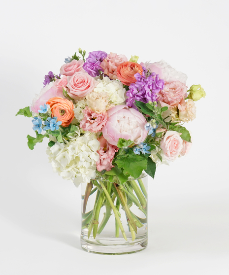 pastel toned floral design featuring peach roses, lavender hyacinth, and pink tulips