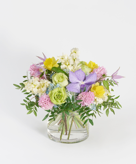 spring floral design of pink hyacinth, lavender orchids, and yellow daffodil