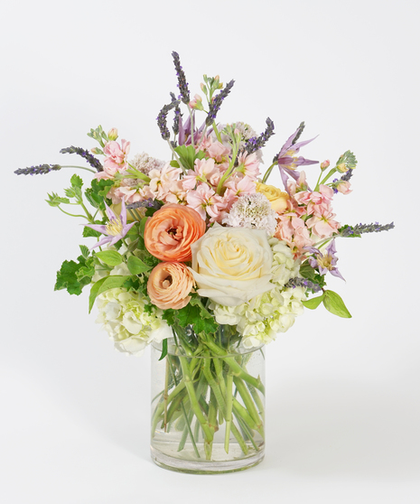 gardeny floral design of peach ranunculus, lavender clematis, white hydrangea and fresh lavender