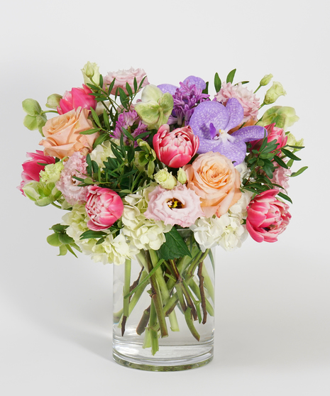 pastel toned floral design featuring peach roses, lavender hyacinth, and pink tulips