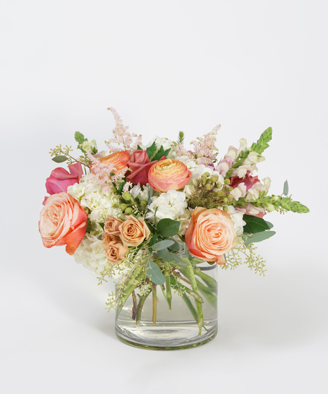 pastel toned floral design of peach ranunculus, mauve roses, and lavender snapdragon