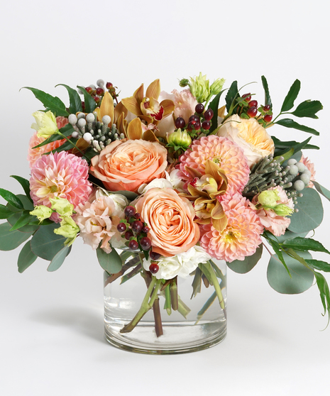 peach dahlias, white hydrangea and bronze orchids arranged with textural greens