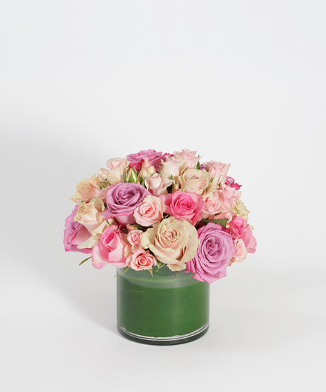low and lush floral arrangement of cream, peach and pink roses