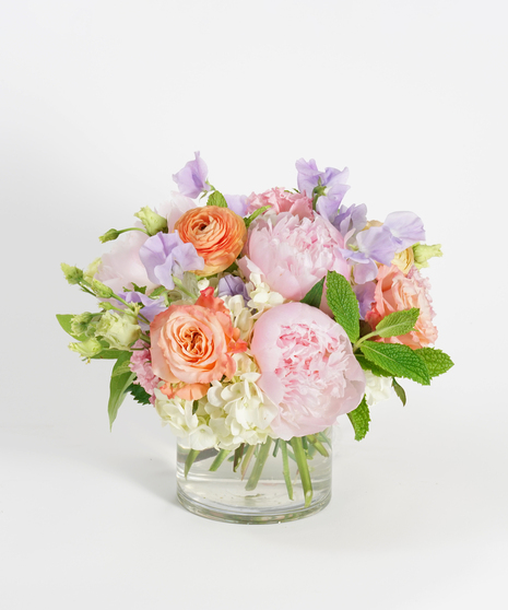 floral arrangement of soft pink peonies, peach ranunculus and white hydrangea.