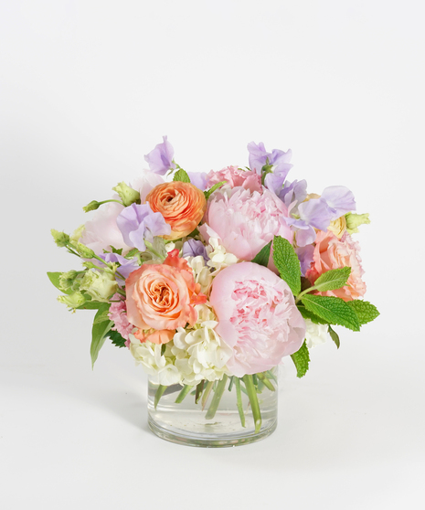 floral arrangement of soft pink peonies, peach ranunculus and white hydrangea.