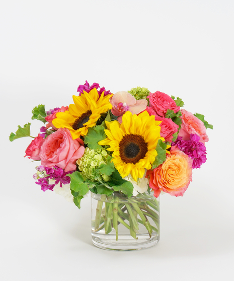 summer floral design of sunflowers, hot pink roses, and fuchsia stock