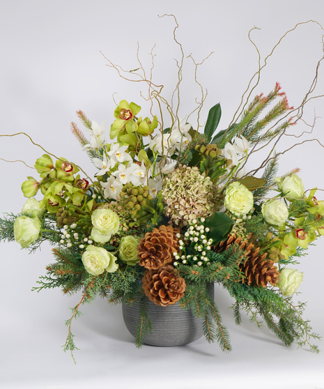 luxury holiday floral design of white and  green orchids and seasonal green designed in a grey stone containers